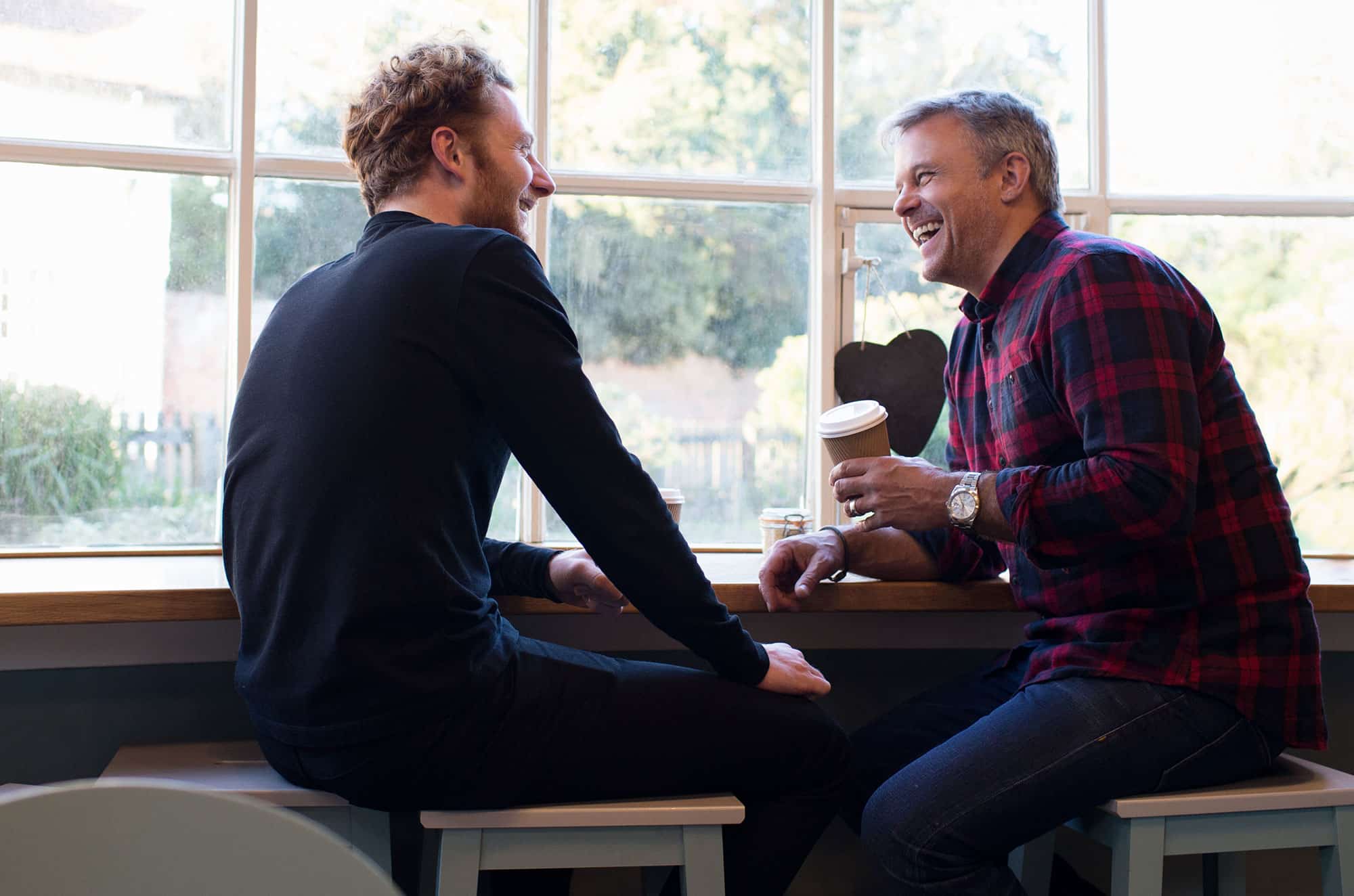 Two men at coughing laughing
